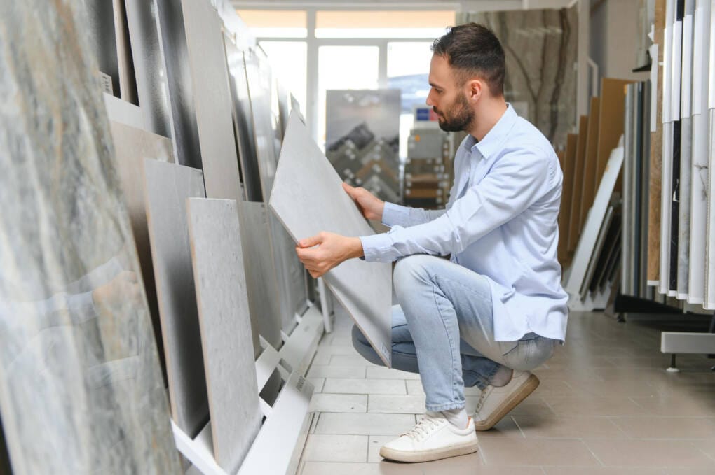 Man examining porcelain tile quality in a Perth tile showroom