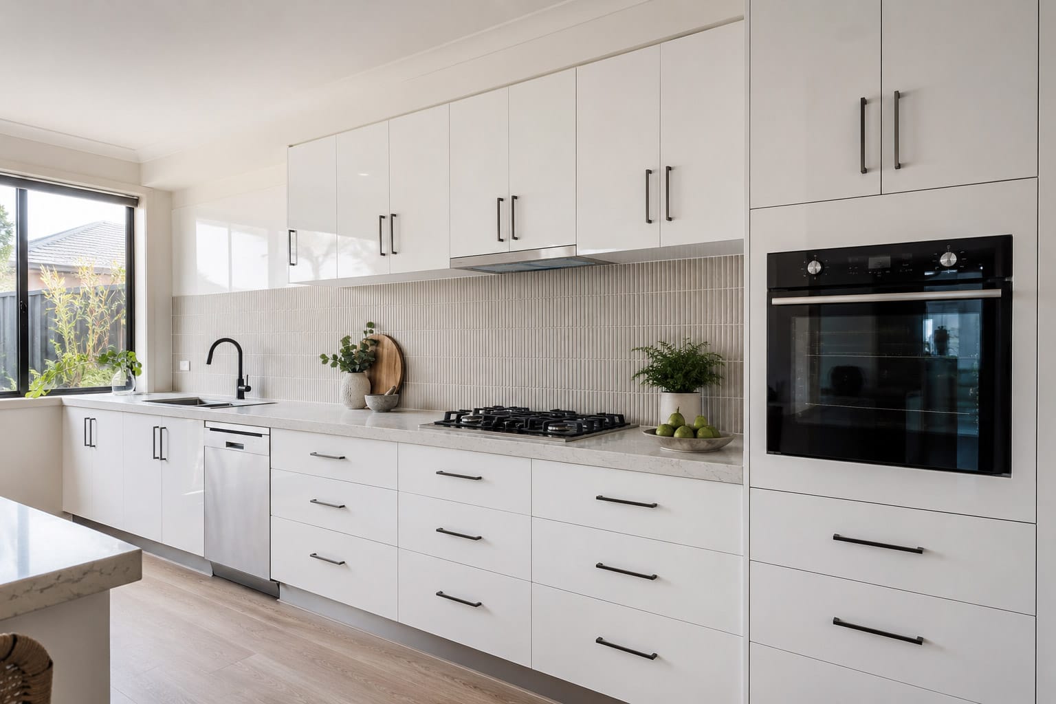 A modern Perth kitchen with high-gloss white cabinets, black handles, a stone-look benchtop and matte black tapware