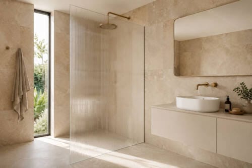 Modern Australian bathroom with a fluted glass shower screen, warm neutral tiles and brushed brass fittings