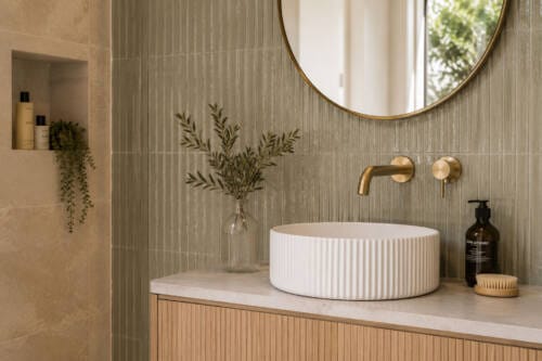Modern bathroom vanity with sage textured wall tiles, fluted vessel basin, brass tapware and timber vanity