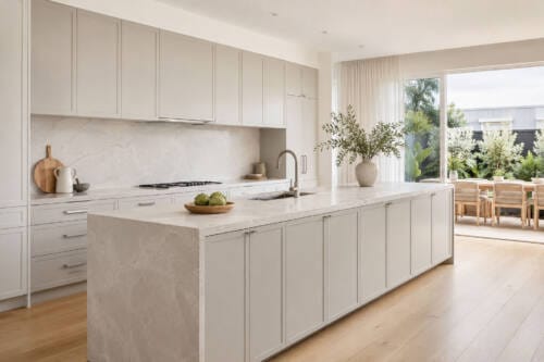 Greige slim shaker kitchen with brushed nickel hardware, stone benchtop and indoor-outdoor design