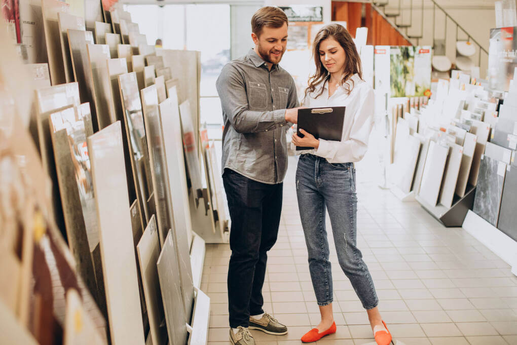 A man and woman at a tile shop, looking over details from a clipboard
