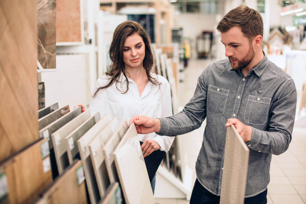 A man and woman browse various tile designs together in a vibrant tile shop
