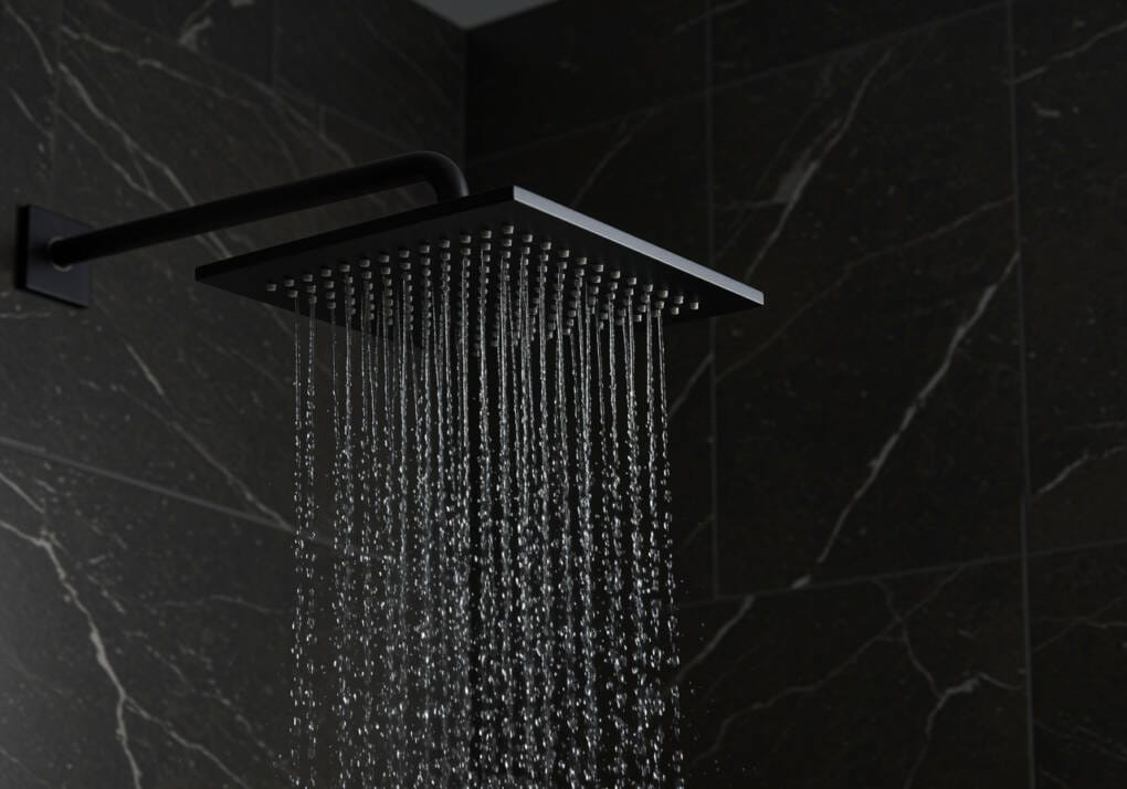 Matte black rainfall shower head with cascading water, installed on a dark marble bathroom wall
