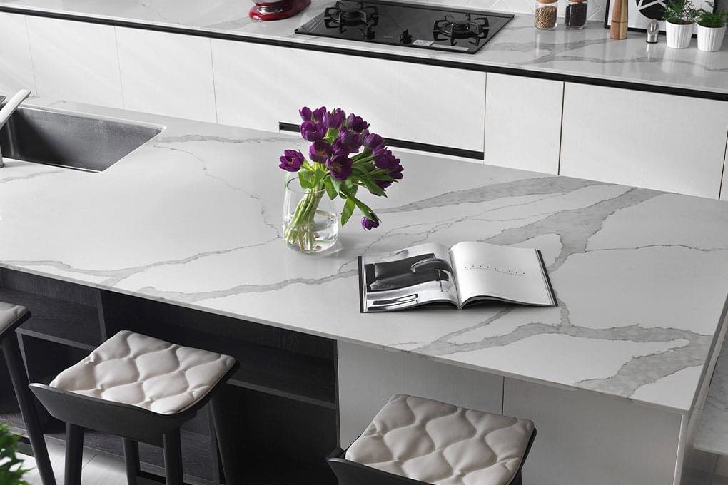 Luxurious Statuario quartz stone kitchen benchtop featuring striking grey vein detailing.