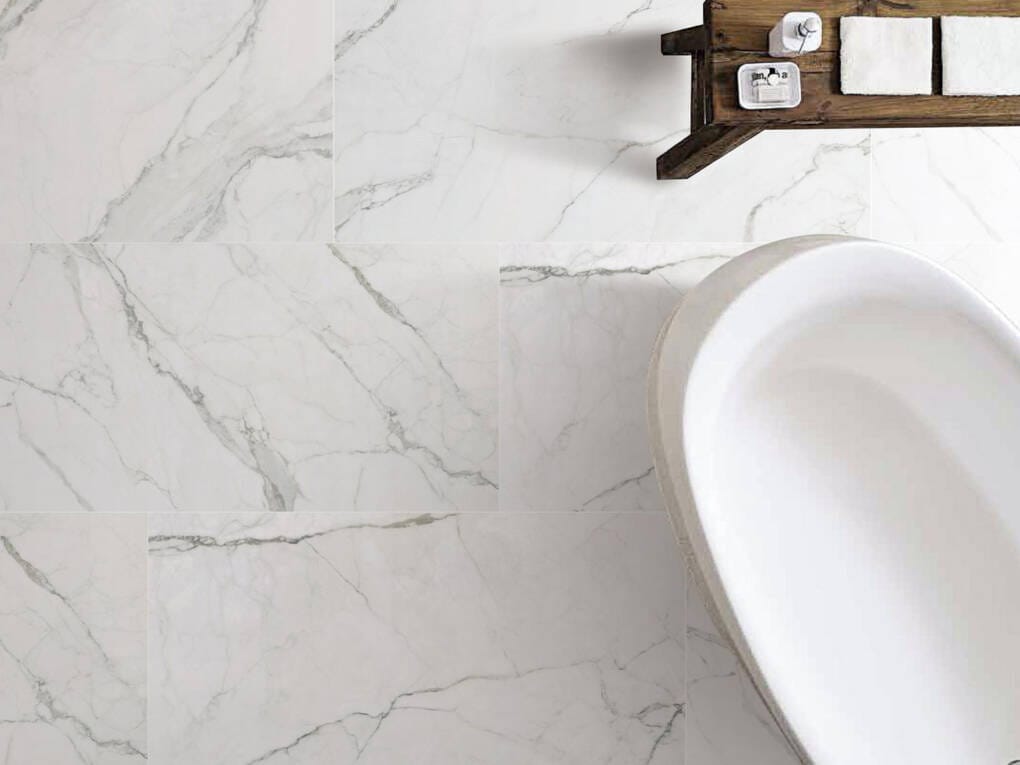 Luxury bathroom featuring marble-look floor and wall tiles with freestanding bath 