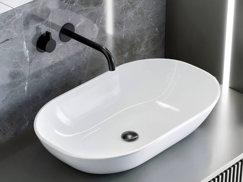 Oval above-counter basin with wall-mounted two-piece tap set on grey marble splashback