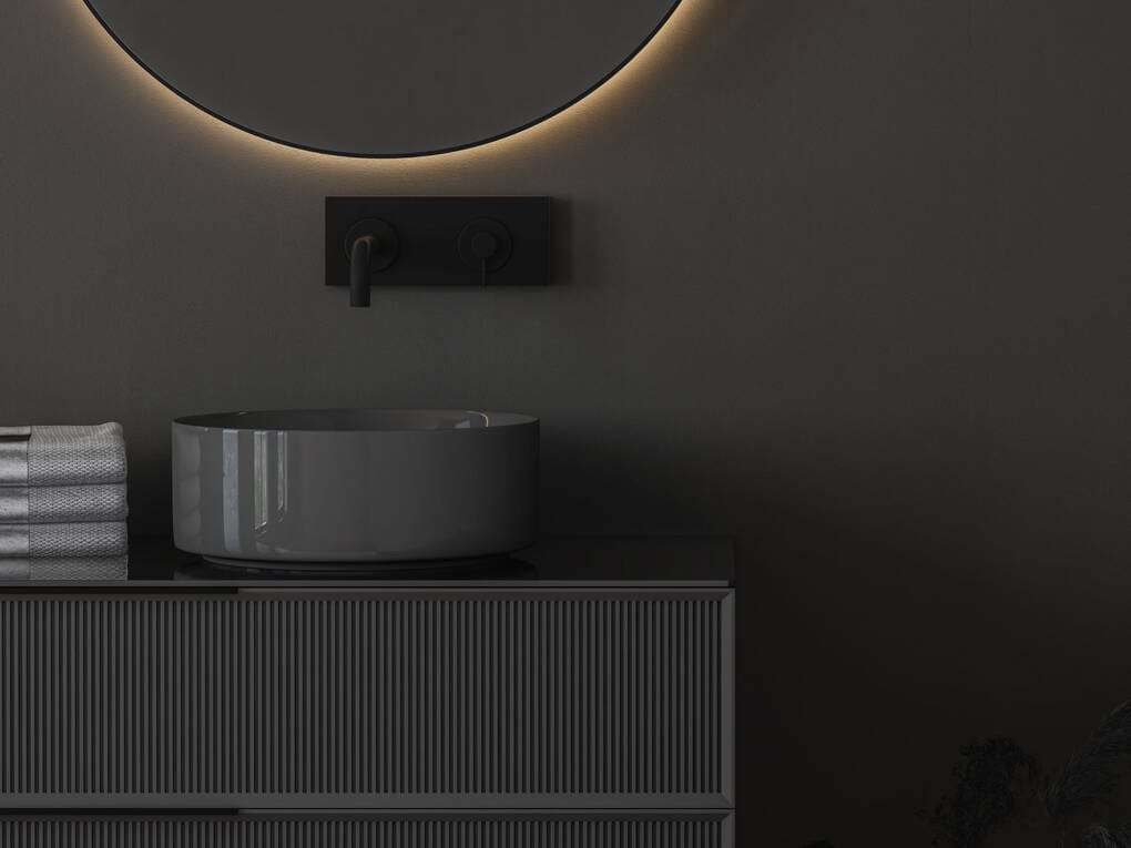 Round grey basin with black backplate-mounted wall mixer and spout on charcoal vanity