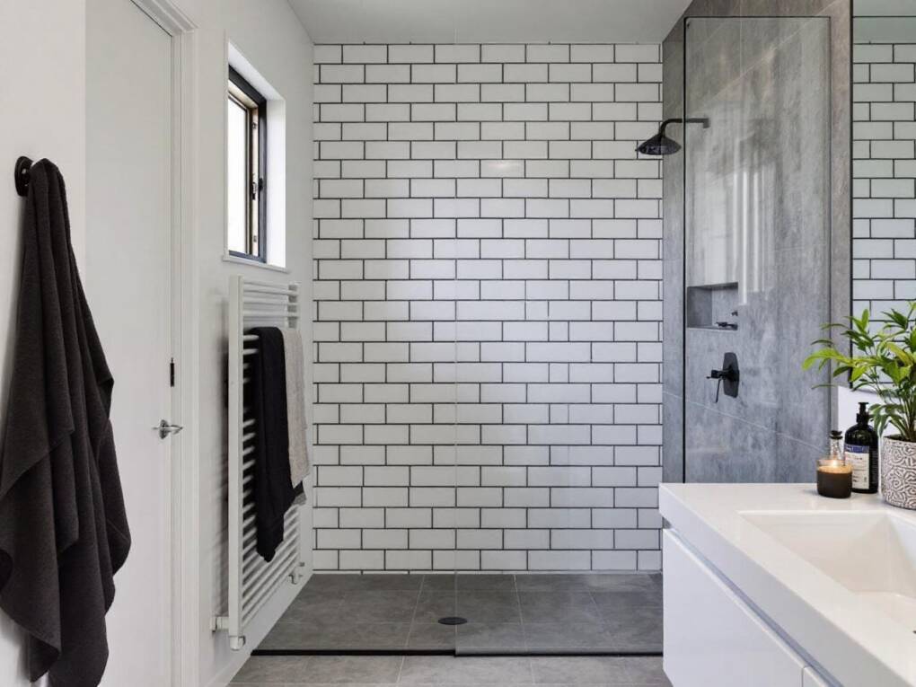 Modern bathroom feature wall with classic white subway tiles and dark grout for bold contrast and timeless style