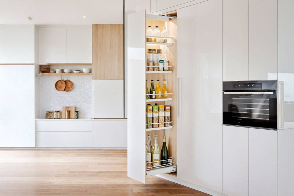 Pull out pantry with slide out shelves in a modern white kitchen