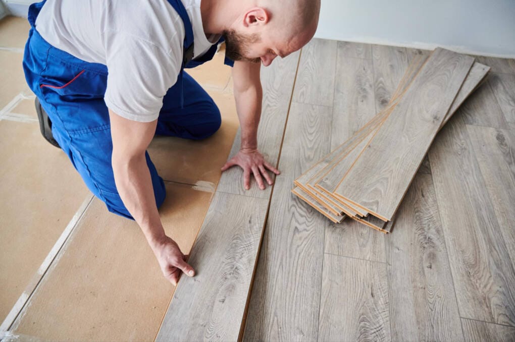 man installing hybrid flooring