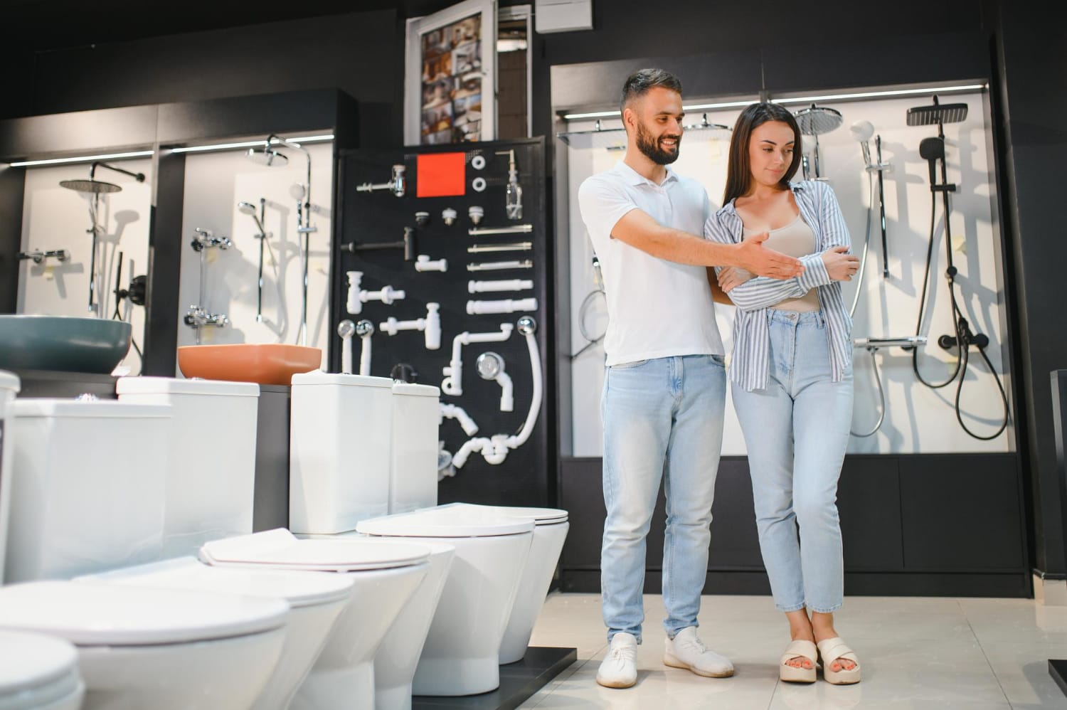 Couple browsing toilets and tapware in a modern Perth bathroom store, exploring fixtures and finishes for their renovation project