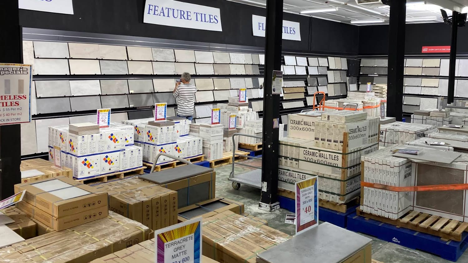 Local customer browsing feature tile displays at Ross’s Discount Home Centre in Perth, highlighting the benefits of shopping locally for tiles and renovation materials