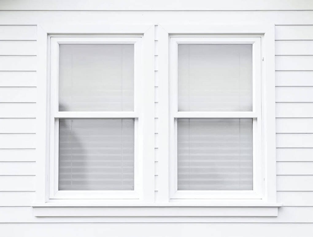 White framed double hung windows on a weatherboard home exterior