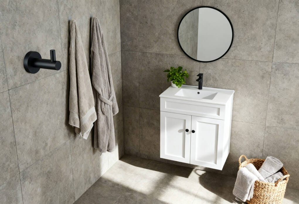 Matte black robe hooks beside a compact vanity showing simple space-saving accessories for small bathrooms