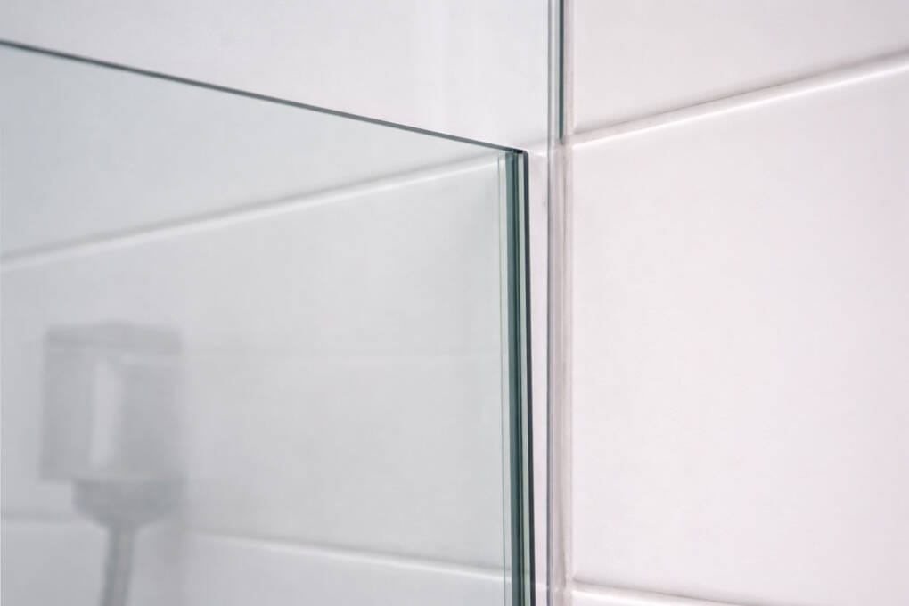 Excess silicone filling the gap between a shower screen and an out-of-square bathroom wall