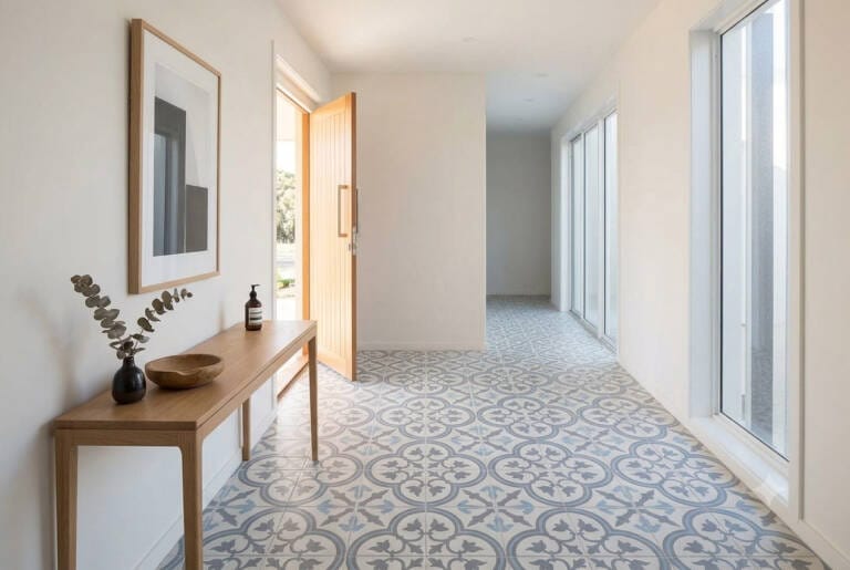 A bright and welcoming home entryway featuring patterned blue and grey ceramic encaustic look floor tiles