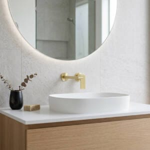 A luxury brushed gold two-piece basin tap set featuring a spout and mixer installed on a modern timber vanity.